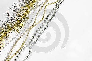 Diagonally silver and golden chain with balls, beads, yellow tinsel. New year decorations on a white background. Christmas