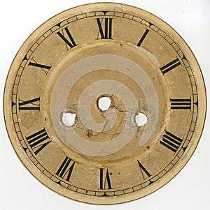 The dial of the old clock with Roman numerals and without arrows, with holes for the mechanism and keys of plant and translation.