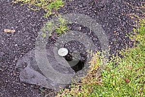 Dial placed in crack of road to measure temperature, Leilani Estate, Hawaii, USA photo