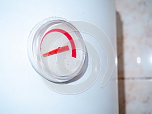 The dial on the water heater. Appliance in the bathroom. Titanium capacitance indicator. primitive technique