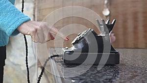 Dialing with an retro rotary phone woman in the office dials the old phone