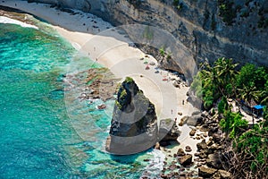 Diamond beach with ocean, palms and rock in Nusa Penida