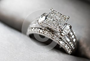 A diamond engagement. ring in a box with glint/reflection. Shimmering princess-cut diamonds.