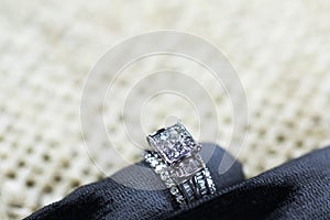 A diamond engagement ring. in a box with glint/reflection. Shimmering princess-cut diamonds.