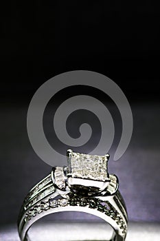 A diamond engagement ring .in a box with glint/reflection. Shimmering princess-cut diamonds.