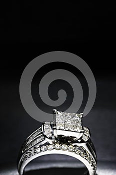 A diamond engagement ring. in a box with glint/reflection. Shimmering princess-cut diamonds.