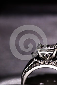 A diamond engagement ring. in a box with glint/reflection. Shimmering princess-cut diamonds.