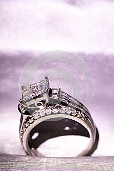 A diamond engagement ring. in a box with glint/reflection. Shimmering princess-cut diamonds.