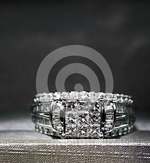 A diamond engagement ring. in a box with glint/reflection. Shimmering princess-cut diamonds.