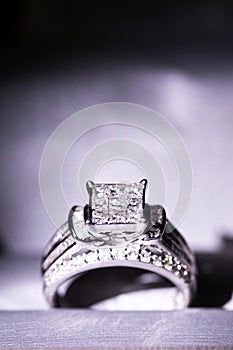 A diamond engagement ring. in a box with glint/reflection. Shimmering princess-cut diamonds.