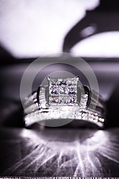 A diamond engagement ring. in a box with glint/reflection. Shimmering princess-cut diamonds.