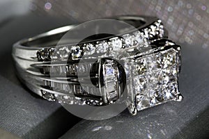 A diamond engagement ring .in a box with glint/reflection. Shimmering princess-cut diamonds.