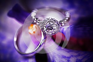 Diamond engagement ring on purple background.