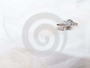 Diamond engagement wedding rings on bridal veil. Wedding accessories, Valentine's day and Wedding day concept