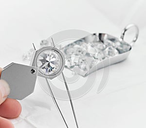 Diamond Grading Under Magnifying Glass with Scoop of Diamonds