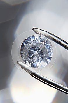 Diamond held by tweezers close-up