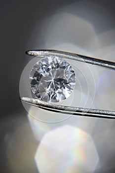 Diamond held by tweezers close-up