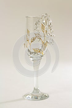 Diamond necklace in a empty glass goblet on a white background