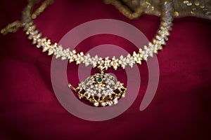Diamond necklace placed on a red backdrop
