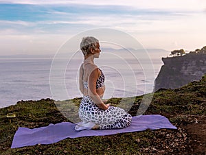 Diamond pose. Beautiful Caucasian woman sitting on the sand in Vajrasana. Yoga and meditation concept. Pranayama breathing