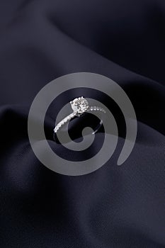 Diamond ring on black silk background with copy space