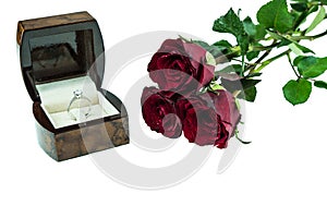 Diamond ring in box with red rose on white background