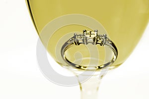 Diamond ring in a glass of white wine