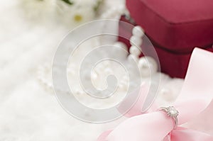 Diamond ring on pearl necklace background