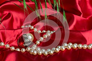 Diamond ring with pearls red background and grass