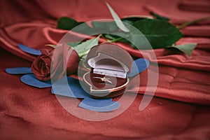 Diamond ring and rose on bright red background