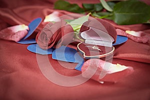 Diamond ring and rose on bright red background