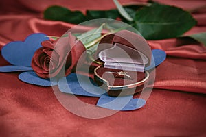 Diamond ring and rose on bright red background