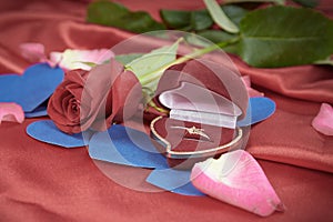 Diamond ring and rose on bright red background