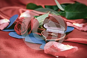 Diamond ring and rose on bright red background