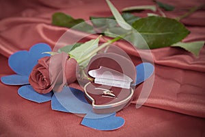 Diamond ring and rose on bright red background