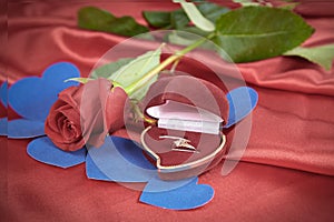 Diamond ring and rose on bright red background