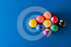 Diamond shape of 9-ball pool balls placed in rack position on blue felt table