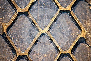 Diamond-shaped dirty tread track of an off-road car tire in warm colors