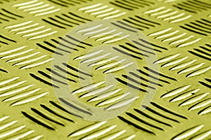 Diamond shaped metal floor pattern with blur effect in yellow to