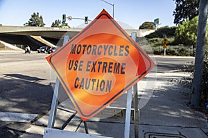 A diamond shaped road sign advising motorcycle riders to use extreme caution