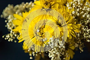 A diamond  wedding band in a boquet of yellow and white flowers - wide angle