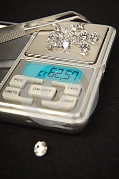 Diamonds on small digital scale in amount of tens of carats