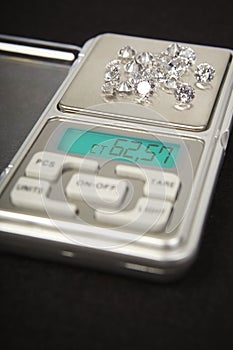 Diamonds on small digital scale in amount of tens of carats