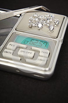 Diamonds on small digital scale in amount of tens of carats