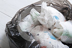 Diapers waste, dirty diapers in trash bag. Disposing of used baby nappies