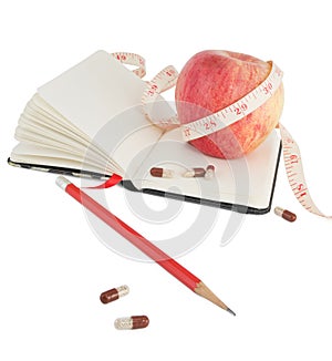 Diary with apple and pills for effective dieting