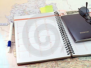 Diary calendar, pen, passport with cash and sunglasses on Thailand map