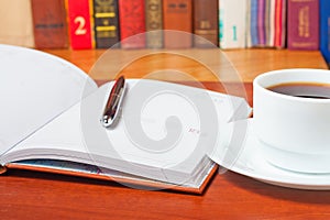 Diary on the desk and a cup of coffee