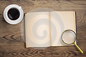 Diary or open book with loupe and coffee cup