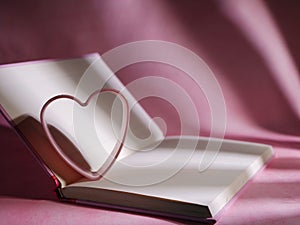 Diary with pink loveheart on pink background photo